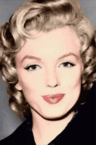 a close up of marilyn monroe 's face with blonde hair and red lips