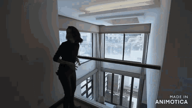 a woman is standing on a balcony with the words made in animotica on the bottom