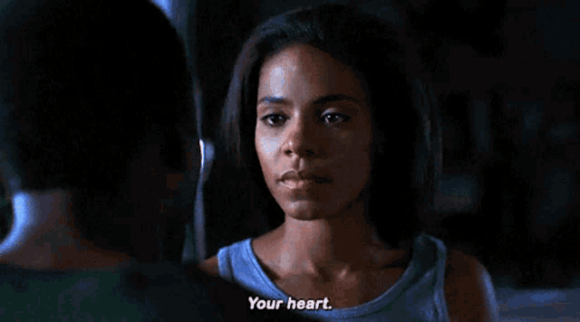 a woman in a blue tank top says " your heart " to a man