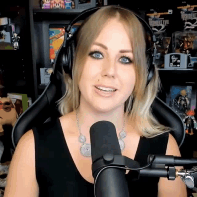 a woman wearing headphones stands in front of a microphone