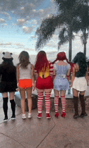 a group of women dressed in halloween costumes are standing next to each other .