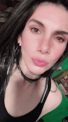 a close up of a woman 's face wearing a choker and earrings