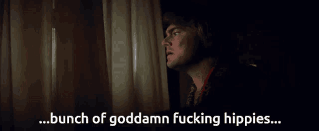 a man looking out of a window with the words bunch of goddamn fucking hippies