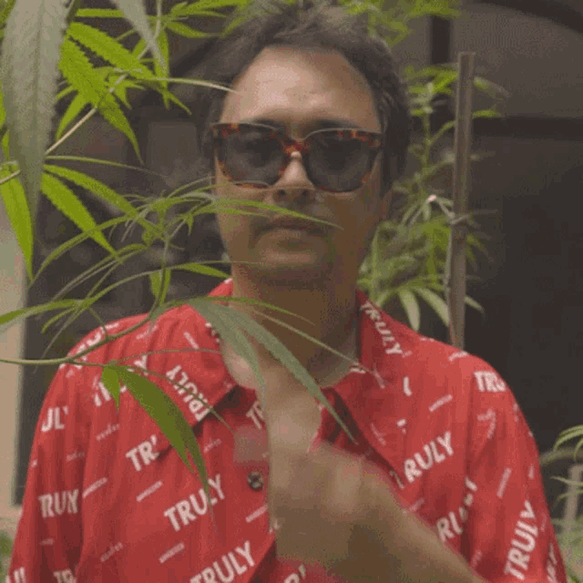 a man wearing sunglasses and a shirt that says truly