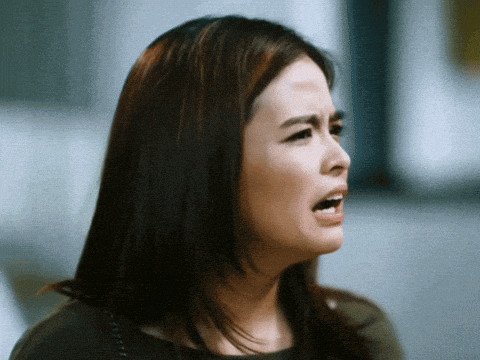 a close up of a woman making a face with her mouth open