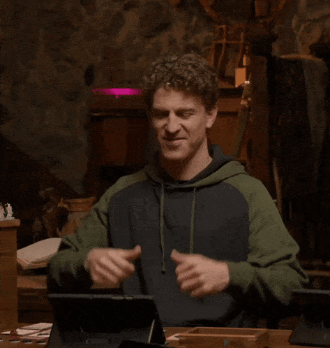 a man giving a thumbs up while wearing a hoodie that says owls on it