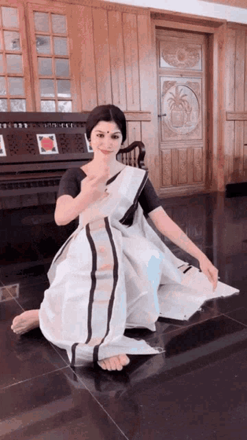 a woman in a black and white dress is kneeling down