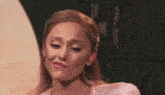 a woman in a white dress is making a funny face while standing on a stage .