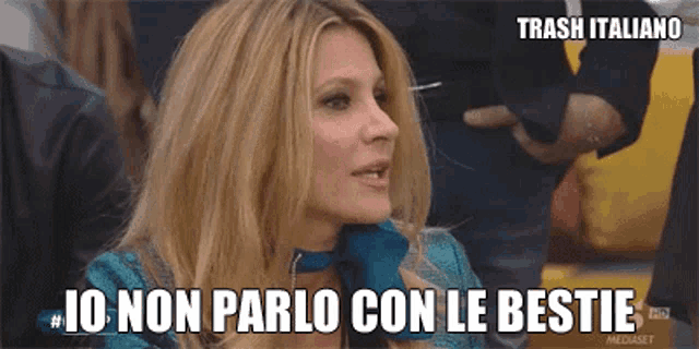 a woman is sitting in a crowd and says io non parlo con le bestie .