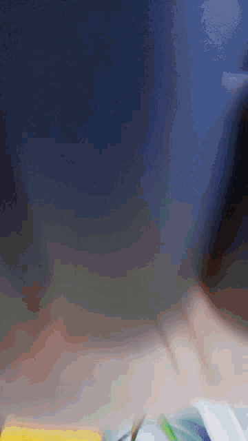 a blurred image of a person 's hand holding a yellow object