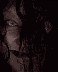 a close up of a person 's face in the dark with their eyes open .