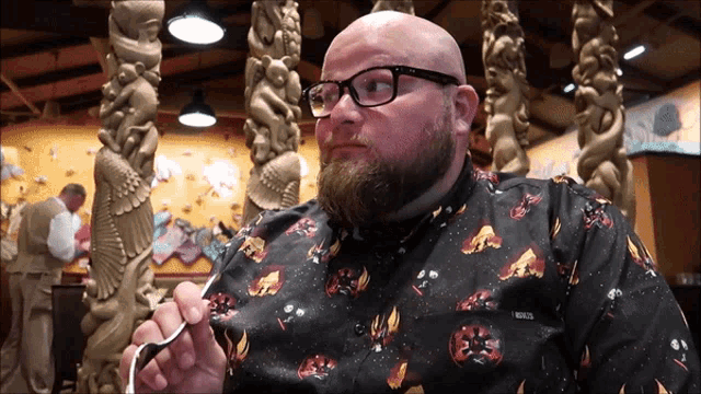a bald man wearing glasses and a shirt that says roots on it