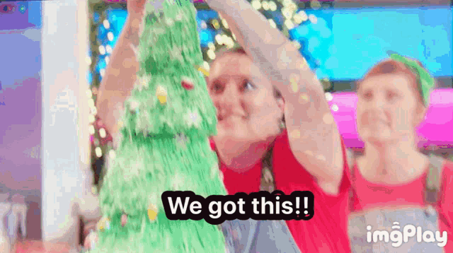 a person holding up a christmas tree with the words we got this written below it