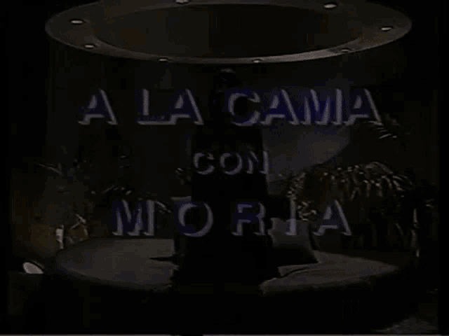 a woman is sitting on a bed with the words a la cama con moria