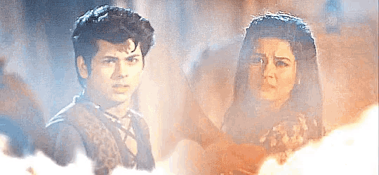 a man and a woman are standing next to each other in a foggy room