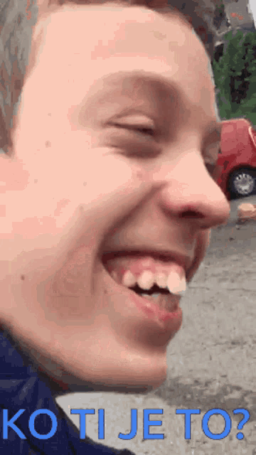 a close up of a young man 's face with the words ko ti je to written below it