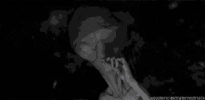a black and white image of an alien smoking a cigarette .