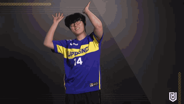 a man wearing a blue and yellow jersey with the number 14