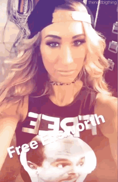 a woman wearing a shirt that says free worth takes a selfie
