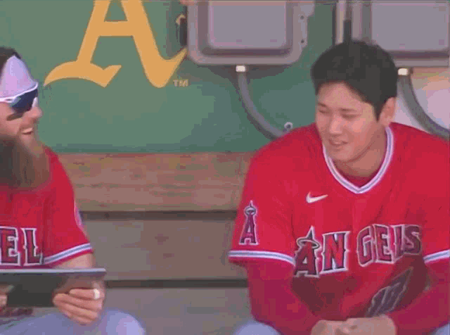 a baseball player wearing a red angels jersey