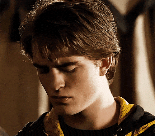 a close up of a man 's face wearing a black shirt and a yellow hoodie