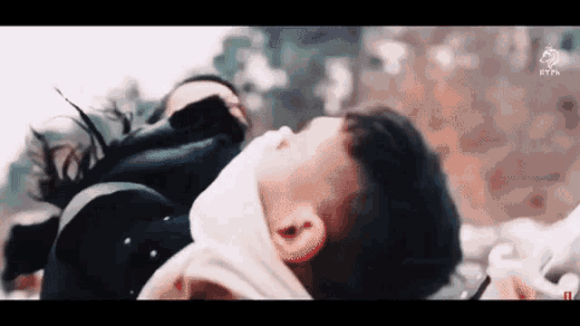 a man and a woman are laying on their backs . the woman is wearing a mask .