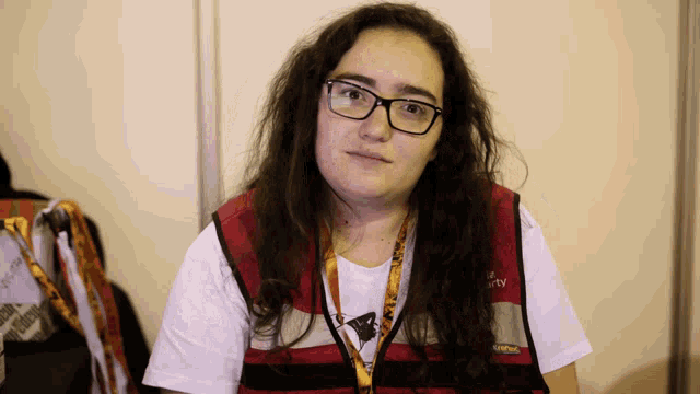 a woman wearing glasses and a red vest that says ' united ' on it