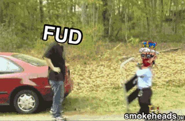 a man standing next to a red car with fud written on the top