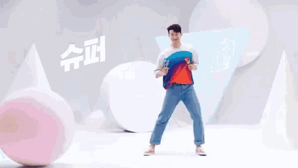 a man in a colorful shirt is holding a bottle of soda and dancing .