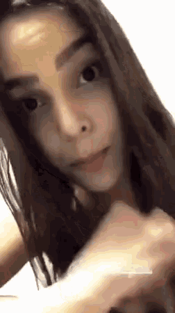 a close up of a woman 's face with long hair and a nose ring .