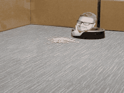 a man 's head is sticking out of a robotic vacuum cleaner