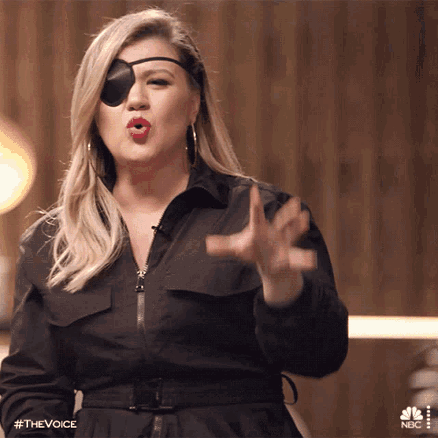 a woman wearing a patch on her eye is making a gesture