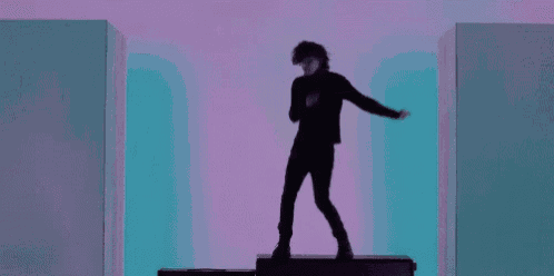 a silhouette of a man standing on top of a suitcase in a room .