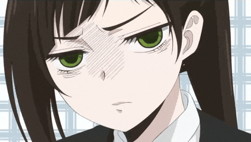 a close up of a girl with green eyes making a face