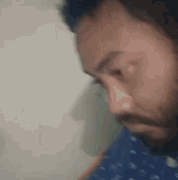 a close up of a man 's face with a beard looking down .