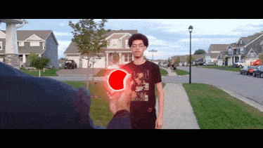 a man wearing a shirt that says ' ucsd ' on it is holding a red object