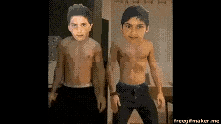 a couple of boys without shirts are standing next to each other .