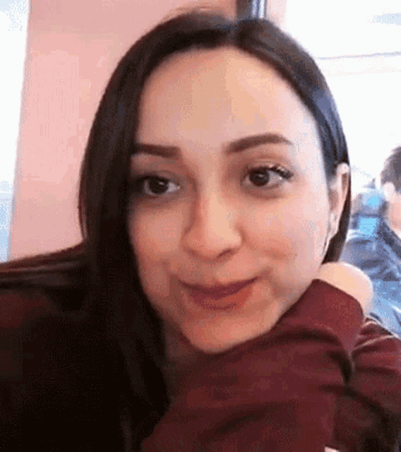 a close up of a woman 's face with her arm around her shoulder .