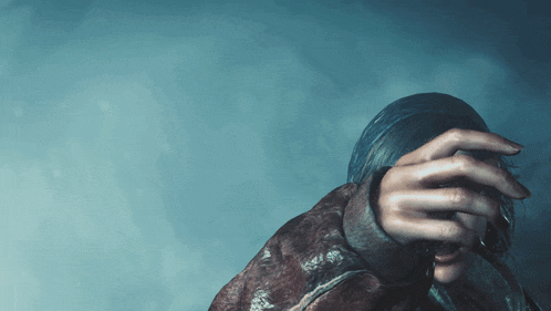 a person covering their face with their hand in a dark room