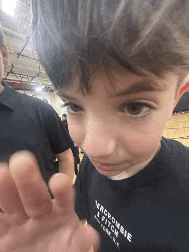 a young boy wearing a black abercrombie & fitch t-shirt
