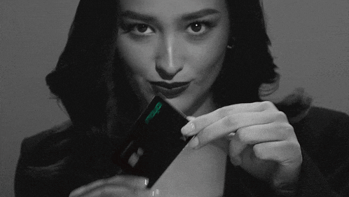 a black and white photo of a woman holding a phone