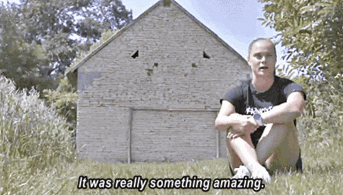 a woman sits in front of a brick building with the words it was really something amazing below her