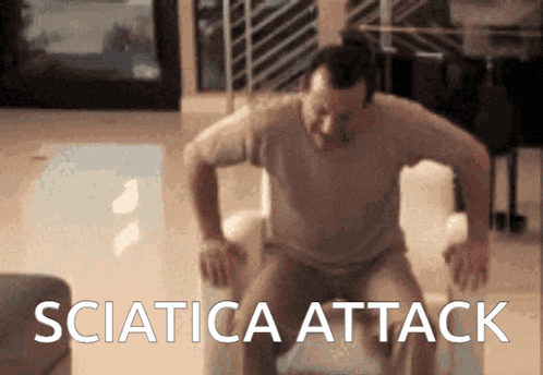 a man is sitting on a couch with the words sciatica attack written on the bottom