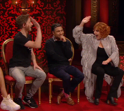 a group of people are sitting in chairs and dancing