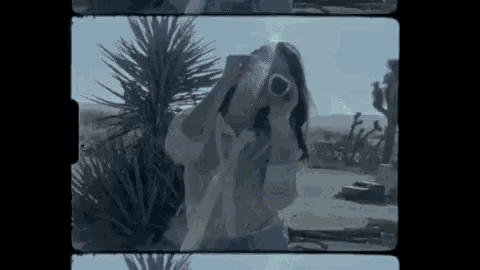 a woman taking a picture with a pink camera