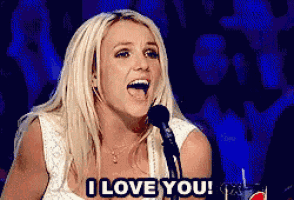 a blonde woman singing into a microphone with the words i love you on the bottom