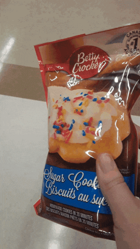 a person is holding a bag of betty crocker sugar cook biscuits au sucre