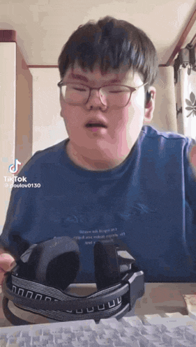 a man wearing glasses and headphones is sitting in front of a computer keyboard