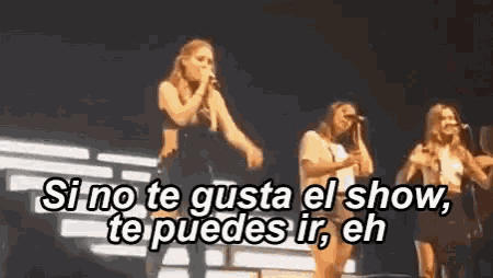 a group of women singing on a stage with the words si no te gusta el show te puedes ir