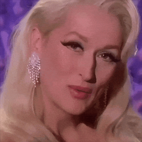 a close up of a woman 's face with blonde hair and earrings